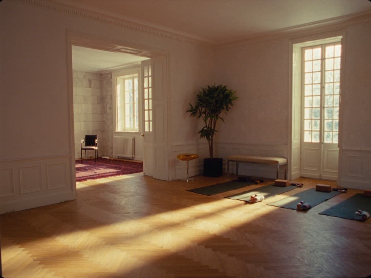 Winter light across the parquet of a high-ceilinged French room, mats and blocks laid out ready